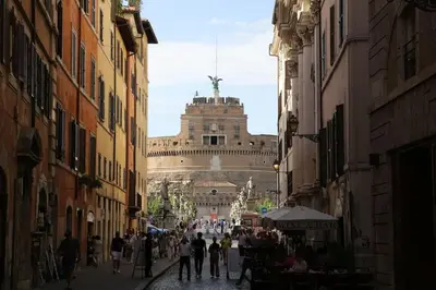 a group of people walking down a street with a building at Casa De' Medici in via Giulia in Rome