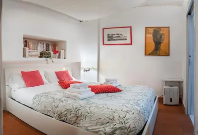 a bedroom with a bed with red and white pillows at Casa De' Medici in via Giulia in Rome