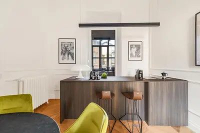 a kitchen with a wooden bar with yellow chairs at Charm and Elegance by The Spanish Steps in Rome