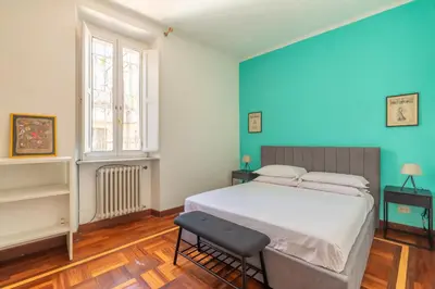 a bedroom with blue walls and a bed and a chair at Campo de Fiori Large and Beautiful Apartment in Rome