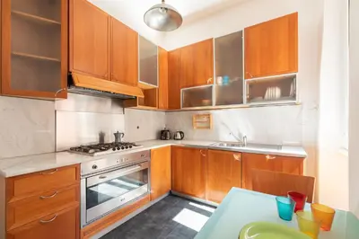 a small kitchen with wooden cabinets and a table at Campo de Fiori Large and Beautiful Apartment in Rome
