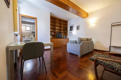 a living room with a table and a chair at FRAM Apartment Fori Imperiali in Rome