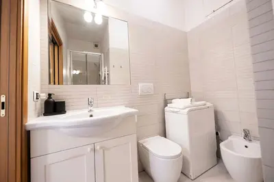 a white bathroom with a sink and a toilet at FRAM Apartment Fori Imperiali in Rome