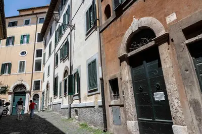 a couple of people walking down a street at FRAM Apartment Fori Imperiali in Rome