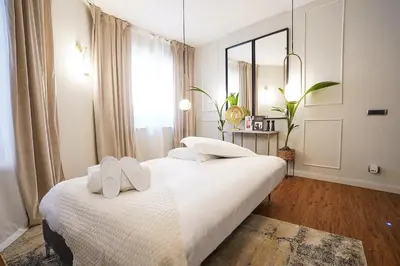two beds in a white room with a mirror at Suite del Grillo - Fori Imperiali - Il Nido d'Amore in Rome