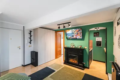 a living room with a fireplace and a green wall at 4BNB - Loft del Papa in Rome