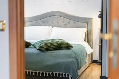 a bedroom with a bed with green sheets and pillows at 4BNB - Loft del Papa in Rome