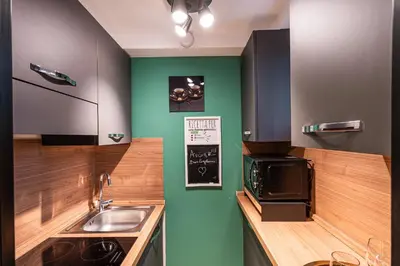a kitchen with green walls and a sink at 4BNB - Loft del Papa in Rome