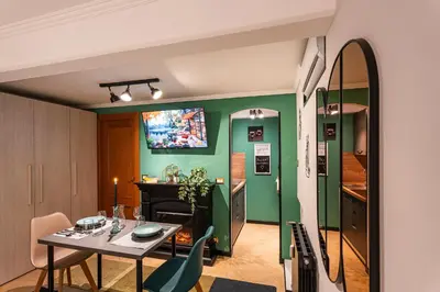 a dining room with a table and a green wall at 4BNB - Loft del Papa in Rome