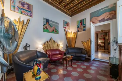 a living room with two chairs and a fan at GuestHost - Pantheon Apartment - L'angolo nascosto dei quadri in Rome