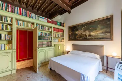a bedroom with a bed and bookshelves filled with books at GuestHost - Pantheon Apartment - L'angolo nascosto dei quadri in Rome