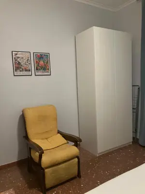 a chair and a cabinet in a room at M&M Pigneto Roma in Rome