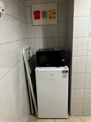 a microwave on top of a refrigerator in a bathroom at M&M Pigneto Roma in Rome