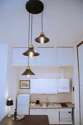 a kitchen with three lights hanging from the ceiling at Casa Donna Olimpia Appartamento Roma in Rome
