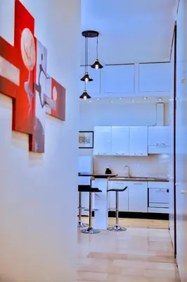 a kitchen with white cabinets and a table and stools at Casa Donna Olimpia Appartamento Roma in Rome