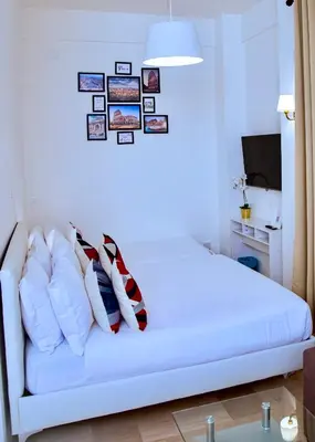 a bedroom with a white bed with pictures on the wall at Casa Donna Olimpia Appartamento Roma in Rome