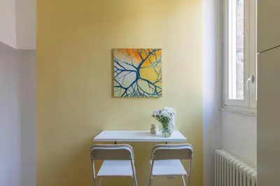 a table with two chairs and a painting on the wall at iFlat Navona Cozy Apartament in Rome