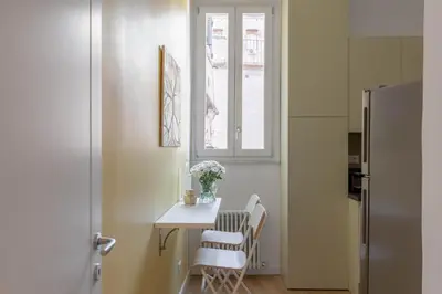 a kitchen with a table and chairs and a window at iFlat Navona Cozy Apartament in Rome