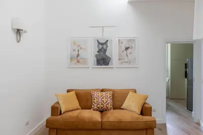 a brown couch in a living room with pictures on the wall at iFlat Navona Cozy Apartament in Rome