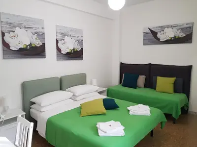 two beds in a room with green and white at Rose Antiche Vatican B&B in Rome