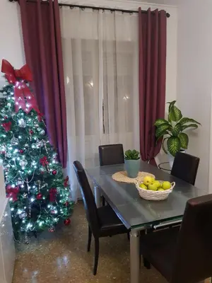 a dining room table with a christmas tree and a bowl of fruit at Rose Antiche Vatican B&B in Rome