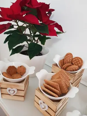 a table with plates of cookies and a vase with red flowers at Rose Antiche Vatican B&B in Rome