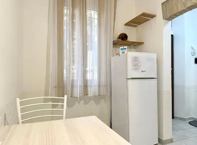 a kitchen with a refrigerator and a table and a chair at Vaticano - 5 min da stazione in Rome