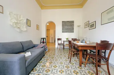 a living room with a couch and a dining room at Cozy Merulana in Rome