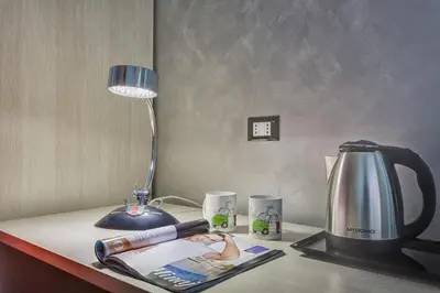 a table with a lamp and a coffee pot and a magazine at Excellence Suite in Rome