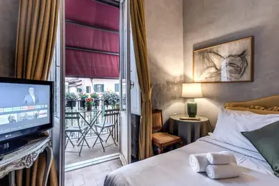 a small bedroom with a bed with red curtains at Stylish 2 BDR Apt with Balcony by Pantheon & Forum in Rome