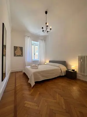 a bedroom with a bed and a chandelier at Flaminia@213 in Rome