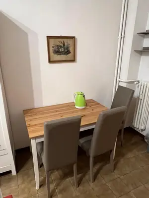 a dining room table with chairs and a green vase on it at Flaminia@213 in Rome