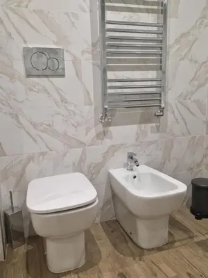a bathroom with a white toilet and a sink at Cozy Luxury Room Turati in Rome