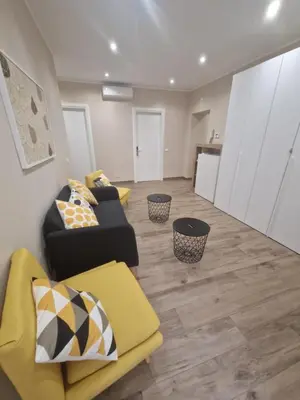 a living room with two couches and a kitchen at Cozy Luxury Room Turati in Rome