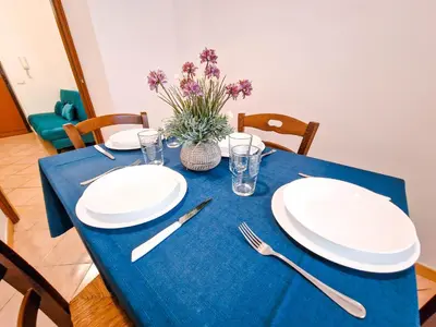 a blue table with white plates and silverware on it at Vatican Shelter in Rome
