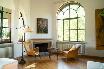 a living room with two chairs and a fireplace at Villa Terme di Caracalla with private Swimming Pool in Rome
