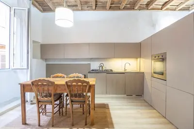 a kitchen with a wooden table and chairs at Colosseum house in Rome
