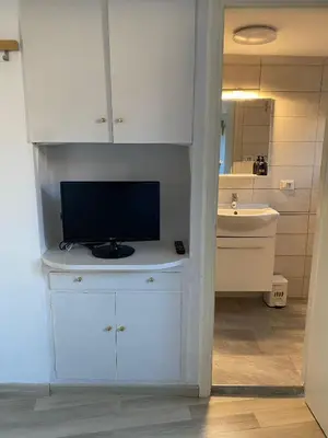 a white cabinet with a television on it in a bathroom at Trastevere onlyone in Rome