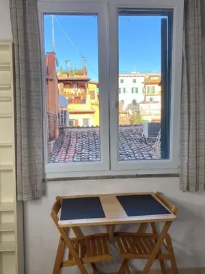 a table in front of a window with a view at Trastevere onlyone in Rome