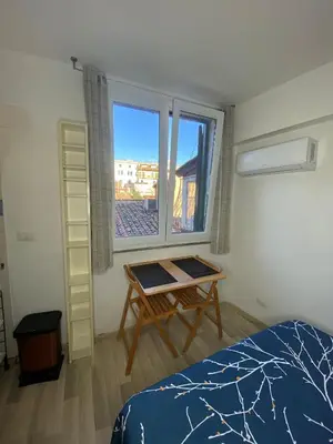 a bedroom with a bed and a table and a window at Trastevere onlyone in Rome
