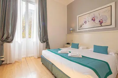 a bedroom with a large bed with blue and white at Residenza Castrense in Rome