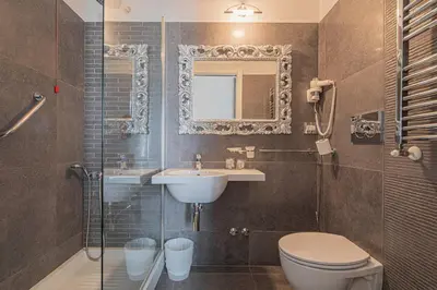 a bathroom with a sink and a toilet and a mirror at Residenza Castrense in Rome