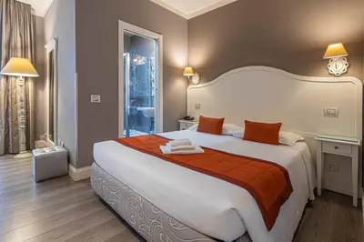 a bedroom with a large bed with orange and white sheets at Suite Castrense in Rome