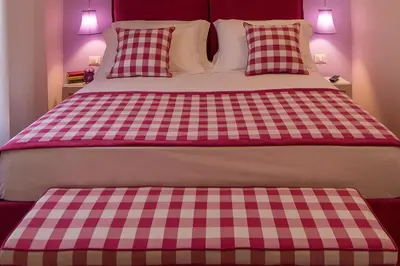 a pink and white bed with two pillows on it at La Porta Rossa di Borgo - Vatican Luxury Suite in Rome