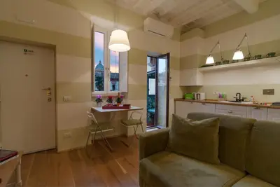 a living room with a couch and a kitchen at La Porta Rossa di Borgo - Vatican Luxury Suite in Rome