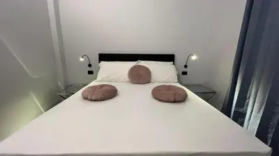 a white bed with two pillows on top of it at Cloud 9 Hotel in Rome