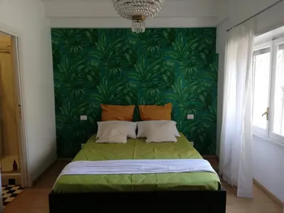 a bedroom with a green bed with a green wall at Vanity Apartment - 4 bedrooms with 4 bathrooms - AC & WIFI in Rome