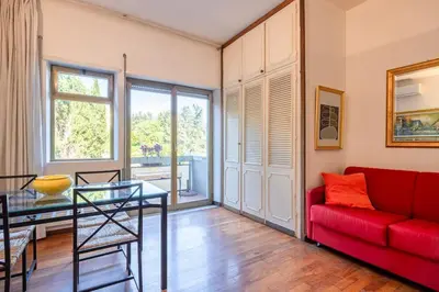 a living room with a red couch and a glass table at Plaza Cheery Suite in Rome