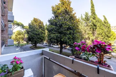 a balcony with flowers on a city street at Plaza Cheery Suite in Rome
