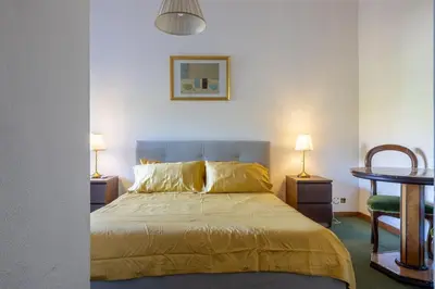 a bedroom with a bed and a table and two lamps at Plaza Cheery Suite in Rome